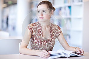 Pretty female college student in a library