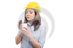 Pretty female constructor enjoying takeaway coffee photo