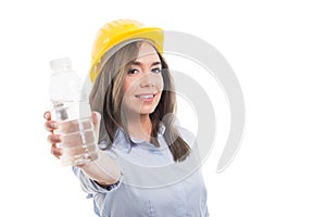 Pretty female constructor offering bottle of water photo