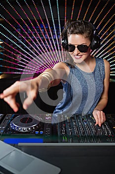 Pretty female DJ playing music