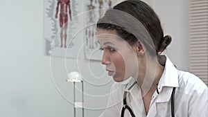 Pretty female doctor listening carefully to a patient in her office.