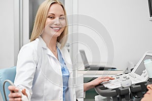 Pretty female doctor posing while doing sonography.