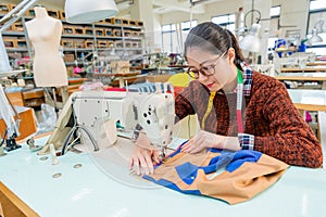 Pretty female sewing worker using tailor machine