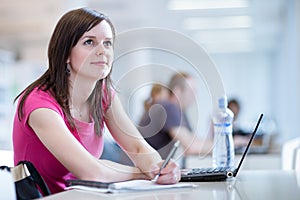 Pretty female student with laptop