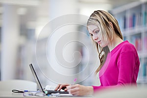 Pretty, female student with laptop and books