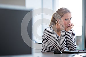 Pretty, female student looking at a desktop computer