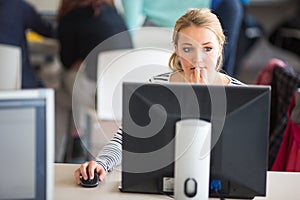 Pretty, female student looking at a desktop computer