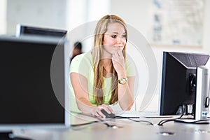 Pretty, female student looking at a desktop computer