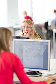 Pretty, female student looking at a desktop computer