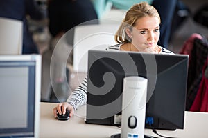 Pretty, female student looking at a desktop computer screen