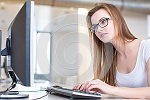 Pretty, female student looking at a desktop computer screen