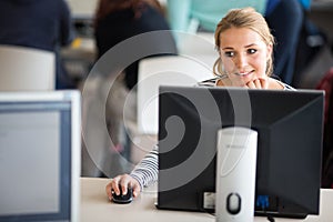 Pretty, female student looking at a desktop computer screen