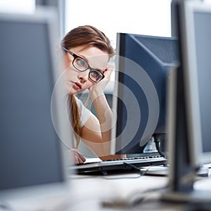 Pretty, female student looking at a desktop computer screen