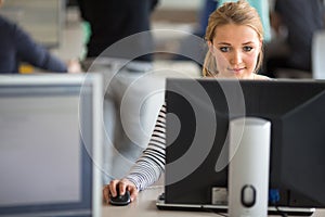 Pretty, female student looking at a desktop computer screen