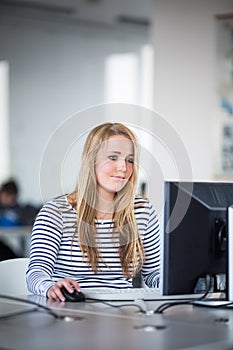 Pretty, female student looking at a desktop computer screena