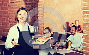 Pretty female waiter showing country restaurant