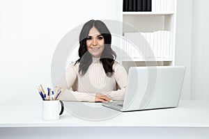 Pretty female worker in office isolated sitting at the desk with computer.