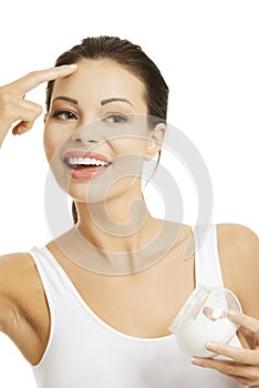 Pretty fit woman with moisturizer cream.