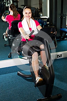 Pretty fit woman pedaling exercise bike fast