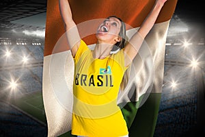 Pretty football fan in brasil t-shirt holding ivory coast flag