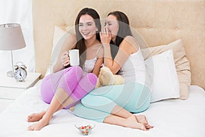 Pretty friends having coffee on bed