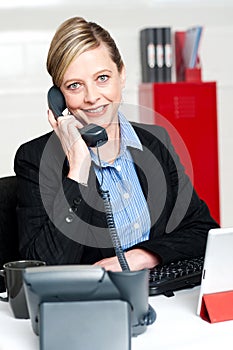 Pretty front desk lady attending clients call