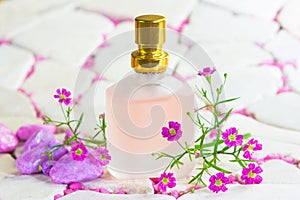 Pretty frosted bottle of perfume with flowers