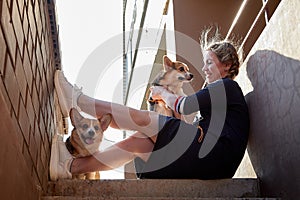 Pretty funny girl with small nice dog big wall of city house in a sunny day