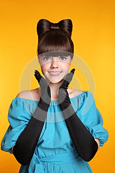 Pretty funny smiling girl beauty portrait. Elegant Fashion Glamorous teen Model wearing black Glamour Gloves. Bow Hairstyle and M