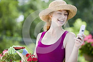 Pretty gardener with cell phone