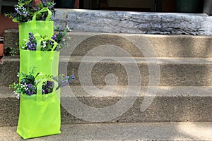 Pretty gift bags with flowers on cement steps
