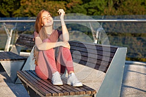 Pretty ginger fitness woman resting during workout outdoor