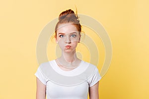 Pretty ginger woman in t-shirt with puffed cheeks