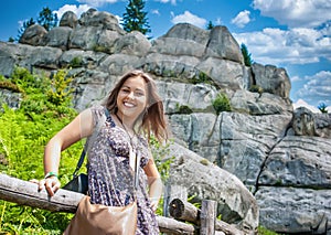 Pretty girl against the background of rocks in the mountains. Smile, joy, journey