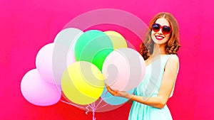 Pretty girl with an air colorful balloons having fun in summer