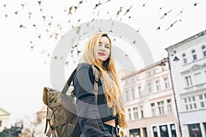 Pretty girl with backpack on background of sky with birds. Journey