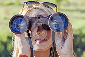 Pretty girl with binoculars looking at the horizon