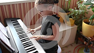 Pretty girl blogger playing classic digital piano during family home concert, smile at the end