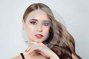 Pretty girl with blowing brown hair, red lips and nails