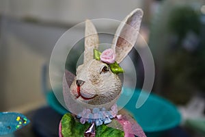 Pretty girl bunny rabbit all decked out for spring with flowers and ribbons against bokeh background