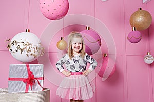 Pretty girl child 3 years old in a dress. Baby in Rose quartz room decorated holiday.