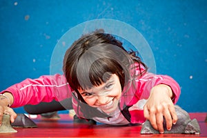 Pretty girl climbing a wall in a playground