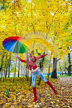Pretty girl with colorful umbrella in autumn park