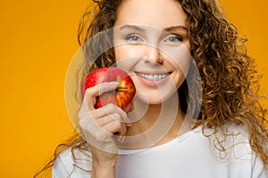 Pretty girl with dental braces on yellow background