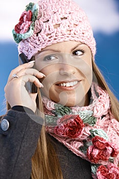 Pretty girl dressed up warm smiling using mobile