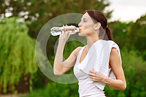 Pretty girl drinking water in park