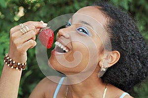 Pretty girl eating a strawberry