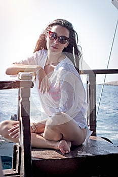 Pretty girl enjoys sunbathing on a yacht