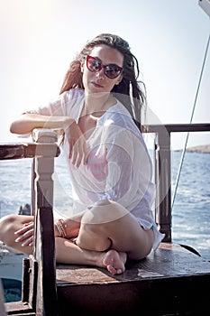 Pretty girl enjoys sunbathing on a yacht photo