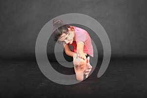 Pretty girl exercising stretching with hand reaching her sole